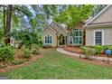 Beautiful single-story house with stone accents, lush landscaping and a charming walkway at 229 Terrane Rdg, Peachtree City, GA 30269