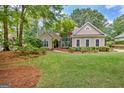 Lovely single-story home features a well-manicured lawn and mature trees in a tranquil setting at 229 Terrane Rdg, Peachtree City, GA 30269