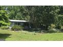 Cozy home featuring a covered porch and surrounded by mature trees at 1100 Kinnett Rd, Covington, GA 30016