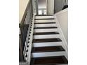 Staircase with white risers, dark wood treads, and black railings at 3608 Davenport Rd, Duluth, GA 30096