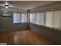 Bright sunroom featuring multiple windows with blinds, light fixture, and hardwood flooring at 957 Astor Ave, Forest Park, GA 30297