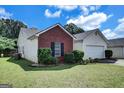 A charming home showcasing a combination of brick and vinyl siding, complemented by a well-maintained lawn at 11367 Vinea Ln, Hampton, GA 30228