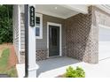 Inviting front porch with brick accents, covered entrance, and a modern door with sidelight at 407 Newland Way, Acworth, GA 30102