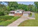 Two-story home with a brick and vinyl exterior, attached garage, long driveway, and manicured lawn at 6023 Highway 20 S, Covington, GA 30016