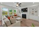 Bright living room with a cozy fireplace, built-in shelving, and large windows at 5350 Woodline View Cir, Hoschton, GA 30548