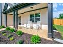 Inviting front porch featuring rocking chairs and meticulous landscaping at 5350 Woodline View Cir, Hoschton, GA 30548