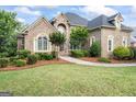 Beautiful brick home featuring a manicured lawn, lush landscaping, and inviting walkway at 719 Bethpage Dr, Mcdonough, GA 30253