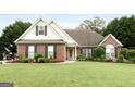 Charming brick home featuring a well-maintained lawn, tidy landscaping, and inviting curb appeal at 235 Surrey Park Dr, Fayetteville, GA 30215