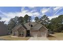 Charming brick home features a two-car garage and a well-manicured lawn at 1128 Carillon Se Dr, Conyers, GA 30013