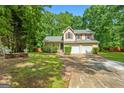 Charming two-story home with a two-car garage and a brick-paved pathway leading to the front door at 11203 Hemlock Rd, Hampton, GA 30228