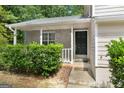 Close-up of a home's front entrance with stone wall and a black door with a covered porch at 11203 Hemlock Rd, Hampton, GA 30228
