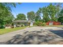 Charming light-blue home featuring a garage with an extra storage building and landscaping at 312 Flat Shoals Church Rd, Stockbridge, GA 30281