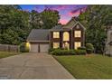 Charming brick front home with a two-car garage, lush lawn and beautiful landscaping at dusk at 5409 Trumpet Vine Se Trl, Mableton, GA 30126