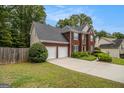 Charming brick front home with a two-car garage, lush lawn and mature landscaping at 5409 Trumpet Vine Se Trl, Mableton, GA 30126