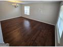 Bright living room featuring hardwood floors and ample natural light from a large window at 590 Dot Dr, Atlanta, GA 30349