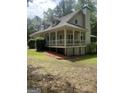 Side angle showing the home's screened in porch, dormer windows, and a charming columned porch at 145 County Line Ct, Fayetteville, GA 30215