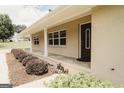 Charming front porch entrance with decorative bushes and a welcoming brown front door at 8394 Banks Mill Rd, Douglasville, GA 30135