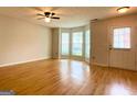 Inviting living room featuring hardwood floors, large windows, and a ceiling fan at 1843 Grove Way, Hampton, GA 30228