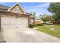 Brick home with two-car garage, lush lawn, and mature landscaping at 3206 Abbott Dr # 12, Powder Springs, GA 30127