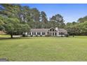 Charming ranch home features a spacious front yard, stone accents, and manicured landscaping at 150 Whitney Way, Fayetteville, GA 30214