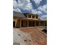 New construction showing long covered porch and garage, framed with wood and featuring a gray shingled roof on a sunny day at 51 Alatus Rd, Hogansville, GA 30230