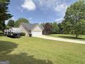 Welcoming single-level home with RV parking, attached garage, and spacious green yard at 105 Carols Ln, Locust Grove, GA 30248