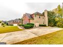 A beautiful house boasts a long driveway, a well-maintained lawn, and lush green landscaping at 1373 Fall River Dr, Conyers, GA 30013