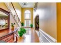 Elegant foyer with hardwood floors, a staircase, and a large window bringing in natural light at 1373 Fall River Dr, Conyers, GA 30013
