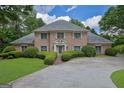 Charming brick home with manicured landscaping, complemented by green shutters and a welcoming entranceway at 2795 Hawthorne Dr, Atlanta, GA 30345