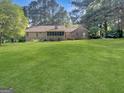 Expansive backyard featuring a deck, screened porch, and lush green lawn at 120 Rolling Brook Trl, Fayetteville, GA 30215