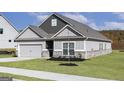 Single-story home with a two-car garage, landscaped yard and a mix of lap and vertical siding at 435 Cantrell Drive, Dallas, GA 30157