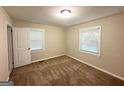 Cozy bedroom with neutral walls, carpet flooring, and two bright windows at 2229 Sharon Way, Decatur, GA 30032