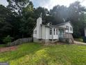View of the side of the house showing the siding, deck, chimney, and the natural landscape at 1504 Colt Ridge Se Ln, Mableton, GA 30126