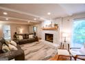 Inviting living room with stone fireplace, wood mantle, hardwood floors, with leather sofas, and plenty of natural light at 170 River Forest Dr, Fayetteville, GA 30214
