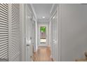 Hallway with wood floors leading to a back door and outdoor view, with multiple white doors along the side at 53 Cobblestone Crk, Peachtree City, GA 30269