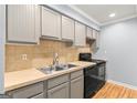Updated kitchen featuring grey cabinets, modern appliances, and tile backsplash at 53 Cobblestone Crk, Peachtree City, GA 30269