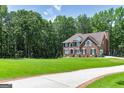 Spacious two-story brick home with a long driveway and expansive front lawn at 20 Allie Dr, Mcdonough, GA 30252