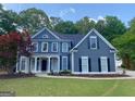 Beautiful two-story home featuring classic design elements, complemented by a lush green lawn at 219 Maple Creek Chase, Woodstock, GA 30188