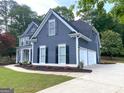 Side view of a home featuring a side-entry garage and complemented by lovely landscaping at 219 Maple Creek Chase, Woodstock, GA 30188