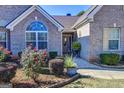 Close up of the front of a beautiful brick home featuring an arched window and well-manicured landscaping at 3008 Brighton Ct, Conyers, GA 30094