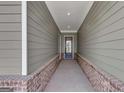 Covered entryway features stylish siding, a brick foundation, and an elegant glass-paneled front door, creating a welcoming entrance at 107 Cedar Brook Dr, Canton, GA 30115