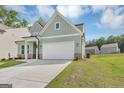 Light blue two-story home boasts a well-manicured lawn, two-car garage, and inviting curb appeal in a suburban setting at 107 Cedar Brook Dr, Canton, GA 30115