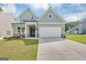 Beautiful two-story home featuring light blue siding, a two-car garage, and a well-maintained lawn in a residential neighborhood at 107 Cedar Brook Dr, Canton, GA 30115