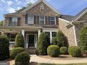 Lovely home featuring a symmetrical design, manicured bushes, and walkway to the front door at 2750 Brentwood Estates Ct, Cumming, GA 30041