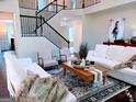 Bright living room with plush seating, wood floors, staircase, and stylish decor create inviting ambiance at 2750 Brentwood Estates Ct, Cumming, GA 30041