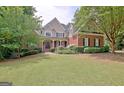 Beautiful two-story brick home featuring a well-manicured lawn and a welcoming front porch at 102 Passage Point, Peachtree City, GA 30269