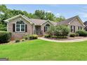 Well-maintained brick home featuring lush green lawn, landscape beds, and a charming walkway at 186 Ashley Dr, Mcdonough, GA 30252