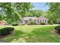 Beautiful brick home with mature trees, green lawn, and manicured shrubbery at 186 Ashley Dr, Mcdonough, GA 30252