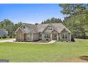Beautiful single Gathering home with stone accents, mature trees, and manicured lawn at 45 Coral Ridge Ct, Palmetto, GA 30268