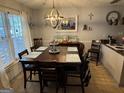 Inviting dining room with a large dark wood table set for six under a modern chandelier at 435 Rosehill Dr, Mcdonough, GA 30253